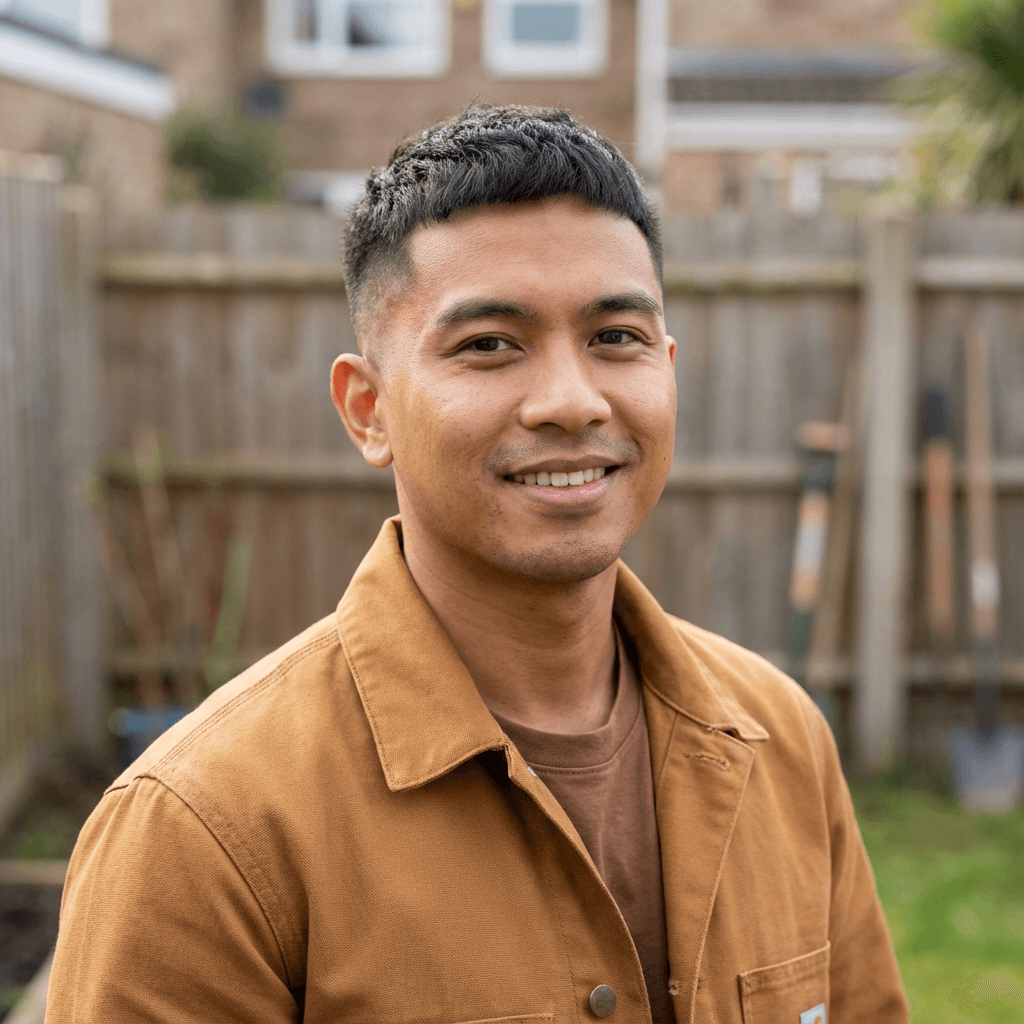 Portrait of Daniel Osei, smiling in a cozy home environment