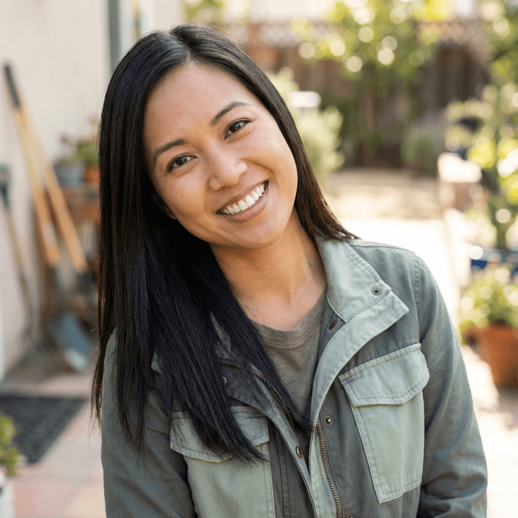 Portrait of Grace Liu, smiling warmly in a bright living room setting